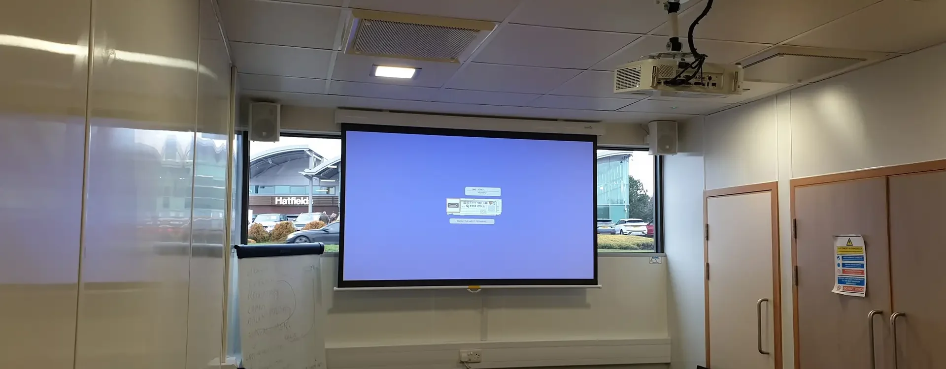 projector and projector screen with speakers in updated av system for training room